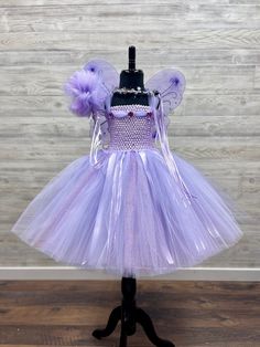 Fuzzy Duckling Design dresses ~ handcrafted for the little princess in your life. Our beautiful dresses feature a stretchy, crocheted bodice that is fully lined for both comfort and modesty. The full skirts sparkle and shine with three layers of high quality tulle in matte, shimmer, and glitter finishes. Satin ribbons, flowers, and jewels are added to make each dress something special. She'll feel like a fairy princess when wearing her matching accessories. This dress includes a matching sparkly Girls Fairy Dress, Fairy Costume For Girl, Lavender Fairy, Fairy Princess Birthday, Ribbon Crown, Fairy Princess Costume, Ribbons Flowers, Birthday Fairy, Princess Wands