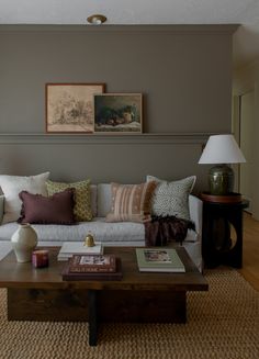 a living room filled with furniture and pillows on top of a coffee table in front of a window