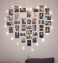 a wall with many pictures and lights hanging from it's sides above a bed