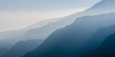 the mountains are covered in mist and fog