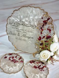 two white roses sitting on top of a table next to some cookies and other decorations