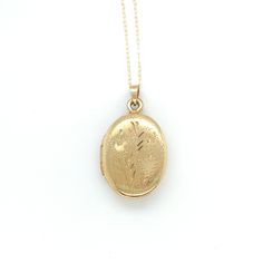 All of our jewelry is guaranteed authentic by our Graduate Gemologist of the Gemological Institute of America (GIA). 14k Yellow Gold Oval Locket with Hearts and Engraved Design (#J6437) 14k yellow gold oval shaped locket on chain. The locket measures just over 1" long with bail by 5/8" wide and has pretty engraved design with two hearts. The pendant includes a new 20" 14k yellow gold chain. The necklace weighs 2.46 dwt., and is contemporary. Pretty! SKU#J6437. 100% Satisfaction Guaranteed! Gold Engraved Oval Cabochon Necklace, Yellow Gold Oval Link Jewelry For Wedding, Oval Formal Jewelry With Hallmarks, Yellow Gold Oval Link Wedding Jewelry, Classic Yellow Gold Oval Cabochon Jewelry, Antique Yellow Gold Necklaces With Hallmark, Heirloom Oval Link Jewelry For Wedding, Heirloom Oval Link Wedding Jewelry, Classic Yellow Gold Jewelry With Hallmark