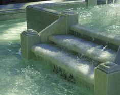 the water is running down the steps in the fountain, and it looks like they have been made out of concrete