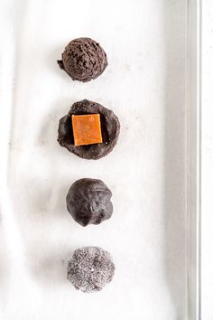 three cookies, one chocolate and one orange are arranged on a baking sheet in the shape of a circle