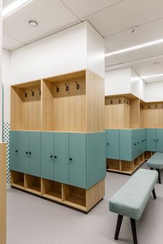 an empty locker room with benches and cabinets in the center, all lined up against the wall