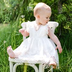 Handmade in the USA A delicately detailed cotton lace with a scalloped edge layered to create a simply elegant look for her special day! Lightly ruffled lace sleeves are a perfect touch to the lace bodice. Pair with her matching Lily accessories to complete her look. 100% light ivory cotton lace Light ivory edge lace Ivory silk ribbon Lace Dress With Ruffles For Garden Party, Elegant Dress With Scalloped Edges For Garden Party, Garden Party Dresses With Lace Sleeves, Elegant Lace Dress With Flutter Sleeves, Garden Party Lace Dress With Ruffles, Ruffled Lace Dress For Garden Party, Garden Party Ruffled Lace Dress, Fitted Dresses With Lace Trim And Flutter Sleeve, Spring Lace Baptism Dress With Lace Trim