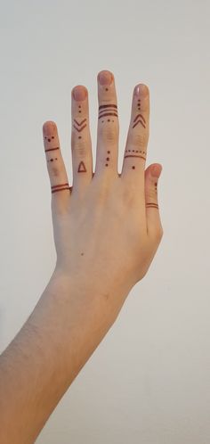 a person's hand with tattoos on their fingers