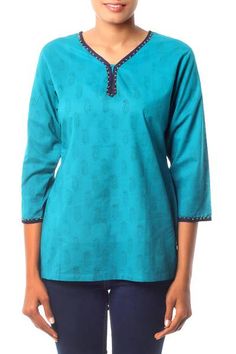 Cool cotton in a rich turquoise tone inspires Isha Jain. She designs this charming tunic with paisley motifs created by hand with the block print technique. Dark blue piping and golden beads complete the charming top. It slips over the head and slits on both sides assure an easy fit. Blue Cotton Tops With Printed Motifs, Blue Block Print Straight Kurta Top, Fitted Cotton Straight Kurta Top, Cotton Block Print V-neck Top, Cotton V-neck Top With Block Print, Festive Cotton V-neck Top, Cotton Block Print Straight Kurta Top, Blue Cotton Straight Kurta Tops, Blue Cotton Tunic With Block Print