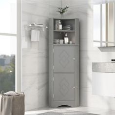 a white bathroom with a gray cabinet next to a window