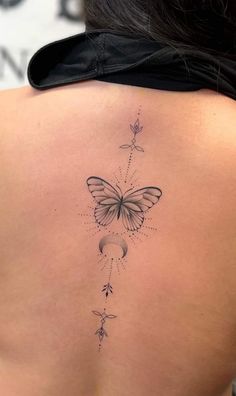 the back of a woman's shoulder with a butterfly and stars tattoo on it