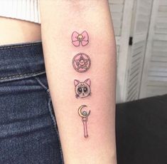 a woman's arm with tattoos on it that include cat, moon and key