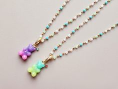 Get yourself an adorable gummy bear necklace! You could make it a personalized necklace by adding a tiny birthstone charm. This could be a great gift for yourself and also for the ones you love.😍 [Material Info.] * Gummy bear charm: Acrylic, 11x17mm(w/o bail), bail with Crystal Cubic Zirconia * Birthstone Charm: Brass, 2mm Cubic Zirconia   * Square Bead Chain: 14K Gold plated, 2.5mm square glass beads(color Mint/Crystal/Rose Quartz/ Peridot), 2mm brass balls, 18in + 2in extension * Tiny Disk Chain: 1.5mm x 0.4mm, Brass, 14K Gold plated, water-resistant coated, 16in + 2in ext. * Ball Station Chain: 1mm x 1mm, 2mm Ball, Brass, 14K Gold plated, Water-resistant coated, 19in + 2in ext. - All lobster clasp function  ● If you are ordering with a birthstone, please write a birthstone color you wa Cute Green Necklace For Gift, Cute Green Necklace For Gifts, Sweet Green Jewelry For Gifts, Cute Handmade Charm Necklaces For Birthday Gift, Mint Crystal, Gummy Bear Necklace, Necklace Bead, Birthstone Colors, Bear Necklace