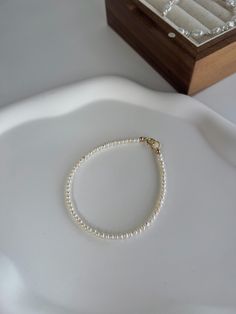 Introducing our Elegant Pearl Bracelet, a timeless accessory crafted with delicate, genuine pearls that add a touch of sophistication to any outfit. This simple yet refined piece is perfect for both everyday wear and special occasions, offering a classic look with a modern twist. The fine gold clasp ensures a secure fit while enhancing the bracelet's luxurious appeal. Whether you're treating yourself or gifting someone special, this pearl bracelet is a beautiful choice that exudes elegance and grace. ❤ If you are looking for a quality chain that keeps its shine, it is ideal for you. Nice package and good for gift ~ ❤ made with 14K plated Cladp with 3mm freshwater pearls. ❤ Cleaning cloth included Standard Size :16. 5cm Please let me know if special size is required. Note: Each natural pear Bracelet Pearl, Bracelet Minimalist, Bracelet Dainty, Dainty Bracelet, Freshwater Pearl Bracelet, Gold Bracelets, Pretty Jewelry, Stackable Bracelets, Minimalist Bracelet