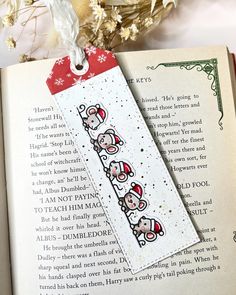 an open book with two little pigs on it and a red tag hanging from the pages