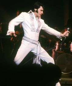 elvis presley performing on stage with microphone in hand