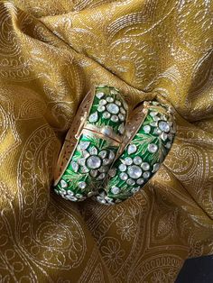 A fine pair of Enamelled Kadas with beautiful design.  Metal Purity: 92.5% Pure Silver Size: 2.25 inches Inner Diameter. Openable, Extra Support Clip. Recommended for wrist sizes of 2.4 Set of Two (2) The weight of the Kadas is 178 grams for the pair. Designer Green Jewelry For Formal Occasions, Designer Green Hallmarked Jewelry, Luxury Meenakari Bracelets, Designer Green Jewelry For Anniversary, Luxury Festive Bracelets, Designer Engraved Jewelry For Wedding, Luxury Bangle For Formal Festive Occasions, Luxury Festive Bracelets For Formal Occasions, Luxury Formal Bracelets For Festive Occasions