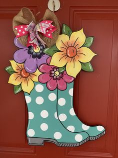 a boot with flowers painted on it is hanging from the front door to be decorated