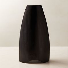 a black vase sitting on top of a white table