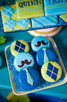 blue and yellow decorated cookies with mustaches on them