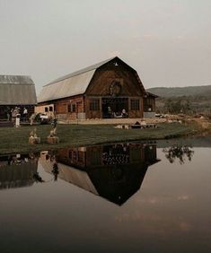 an old barn is reflected in the water