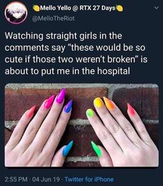 two hands with multicolored nail polish holding each other's fingers in front of a brick wall