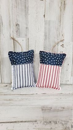 two red, white and blue pillows sitting on top of a wooden floor next to each other