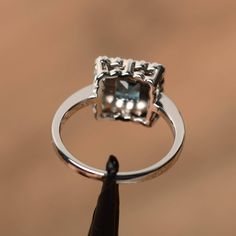 It is a real London blue topaz ring, princess cut, measures 5mm*5mm, weight about 0.83 cts. The basic metal is sterling silver and plated with rhodium. To change the metal to a solid gold (white/rose) or platinum is also available, please ask for a quotation if you want. You can also go to my shop Home for more elegant rings: https://www.etsy.com/shop/godjewelry?ref=hdr_shop_menu London blue topaz is birthstone of November More London blue topaz rings: https://www.etsy.com/shop/godjewelry?ref=se 14k White Gold Princess Cut Jewelry With Halo Setting, 14k White Gold Princess Cut Halo Jewelry, Princess Cut 14k White Gold Jewelry With Halo Setting, Princess Cut Halo Jewelry In 14k White Gold, Blue Topaz Cushion Cut Ring With Halo Setting, Cushion Cut Blue Topaz Ring With Halo Setting, Fine Jewelry With Princess Cut Blue Topaz, Elegant Blue Topaz Princess Cut Jewelry, Elegant Princess Cut Blue Topaz Ring