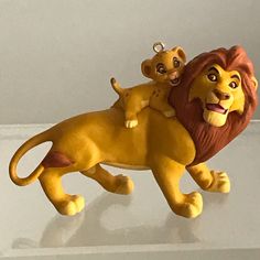 a lion figurine with a baby sitting on it's back