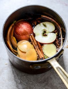 a pot filled with apples and cinnamons on top of a table