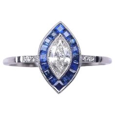 a white gold ring with blue and white diamonds on the side, set in 18k white gold