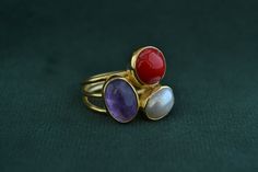 A multi-stone ring that is made with solid Sterling Silver (925 Silver). The outer layer is gold plated with 22K Gold, and the 3 stones decorating the ring are Coral, Amethyst and Pearl. Elegant Stackable Rings With Natural Stones For Anniversary, Unique Gold Multi-stone Amethyst Ring, Unique Multi-stone Gold Amethyst Ring, Gold Amethyst Ring With Natural Stones As Gift, Gold Stackable Rings With Stones For Gift, Elegant Stackable Rings With Stones As Gift, Pearl And Amethyst, Mens Gemstone Rings, 925 Silver Ring