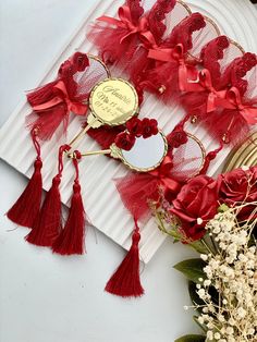 a table with red flowers and decorations on top of it, including a white plate