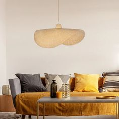 a living room filled with lots of furniture next to a wall mounted light hanging from the ceiling