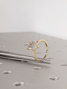 a diamond ring sitting on top of a piece of metal