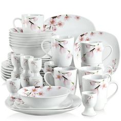 a bunch of white dishes and cups with pink flowers on them