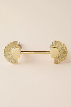 a pair of gold colored metal barbells on a white background with an oval design