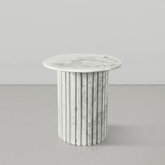 a white marble table sitting on top of a gray floor