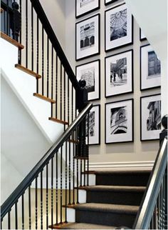 a staircase with pictures on the wall and carpeted steps leading up to the second floor