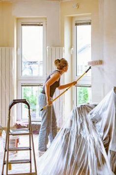 a woman with a mop is cleaning the walls in a room that has been renovated