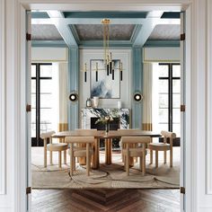 the dining room is decorated in blue and white with gold accents on the walls, along with an oval wooden table surrounded by beige chairs