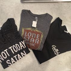 What A Fun T-Shirt Bundle! Nwt All Of These Tee's Are Size Large, But Fit Like A Medium! Details: "Not Today Satan" Black Marble Tee By Birch Bear Is 95% Poly, 5% Cotton. Lightweight. Approx. 32" Bust "Lone Star Music" Tee Is 65% Poly, 35% Cotton. Dark Grey, Lightweight. Approx. 34" Bust. "Gas Monkey Garage" Black Tee Is 100% Cotton. Medium Weight. Approx. 34". Monkey Garage, Gas Monkey Garage, Gas Monkey, Music Tees, Not Today, Music Star, Lone Star, Black Marble, Medium Weight