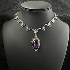 "This elegantly ornate necklace is made with antique silver tone centerpieces, featuring filigree and leaf details. Its mesmerizing design is accented with dazzling dark amethyst purple glass crystals with a large high quality faceted jewel hanging at its center.  Decorated portion is 8 1/2\" wide and 2 1/4\" tall in the very center.  Necklace length is adjustable with soldered stainless steel cable chain, lobster clasp and extender. If you would like a different length, please send us a message. If you don't see items with a color you want, feel free to ask about availability." Gothic Amethyst Necklace, Ornate Necklaces With Intricate Design For Formal Occasions, Silver Filigree Bridal Necklace For Formal Occasions, Formal Silver Filigree Bridal Necklace, Ornate Jeweled Necklaces, Antique Silver Bridal Necklace For Formal Occasions, Antique Silver Necklace With Intricate Design For Formal Occasions, Formal Metal Necklace With Oxidized Finish, Formal Antique Silver Necklace With Intricate Design