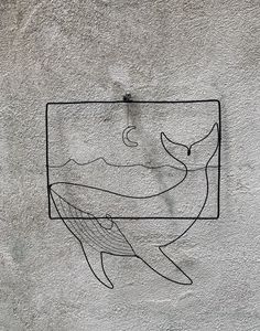 a drawing on the side of a building with a whale in it's mouth