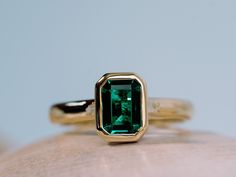 a close up of a ring with a green stone on it's center piece