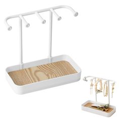 a pair of white jewelry stands next to a wooden tray with beads hanging from it