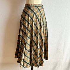 Knife pleat wool blend skirt in earth tones Closes with side zipper and button Era: 1970s Label: Daniel Place Fabric: 30% Wool, 70% Polyester Fabric Care: Dry clean Lining: None Colors: Orange, teal, yellow, black Closure: Zip, button Pockets: None Measurements, laid flat (in inches) Across waist 12 Across hips 21 Total length 32 Marked Size: 5, vintage sizing, see measurements Condition: Good condition, no issues 5 Dimension, Knife Pleat, Orange Plaid, Vintage 1970s, Fit & Flare, Pleated Skirt, Fabric Care, Favorite Outfit, Wool Blend