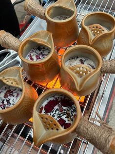 four cups filled with food sitting on top of a metal rack