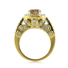 a yellow gold ring with diamonds on the sides and a brown diamond in the center