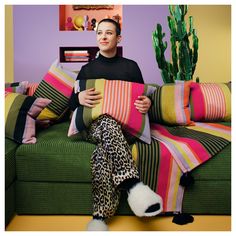 a woman sitting on a couch holding pillows