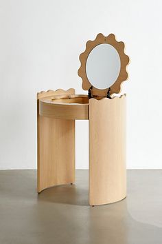 a wooden table with a mirror on top of it next to a stool that is shaped like a flower